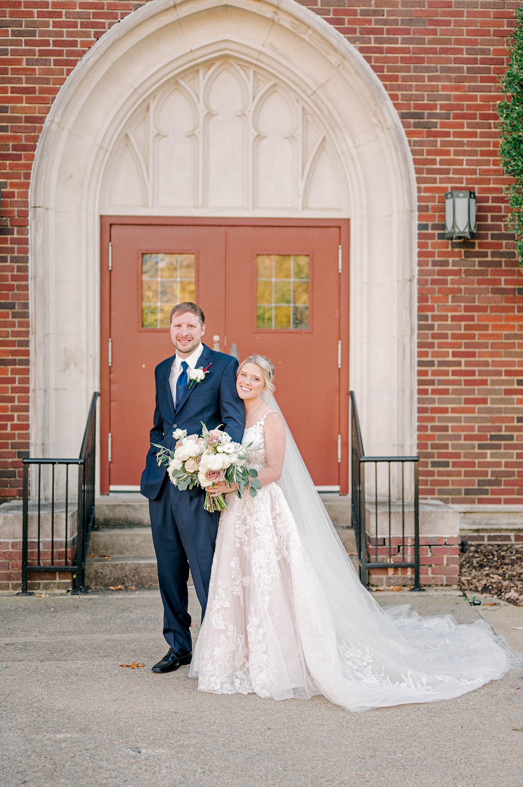 Bride and groom smiling in front of church
