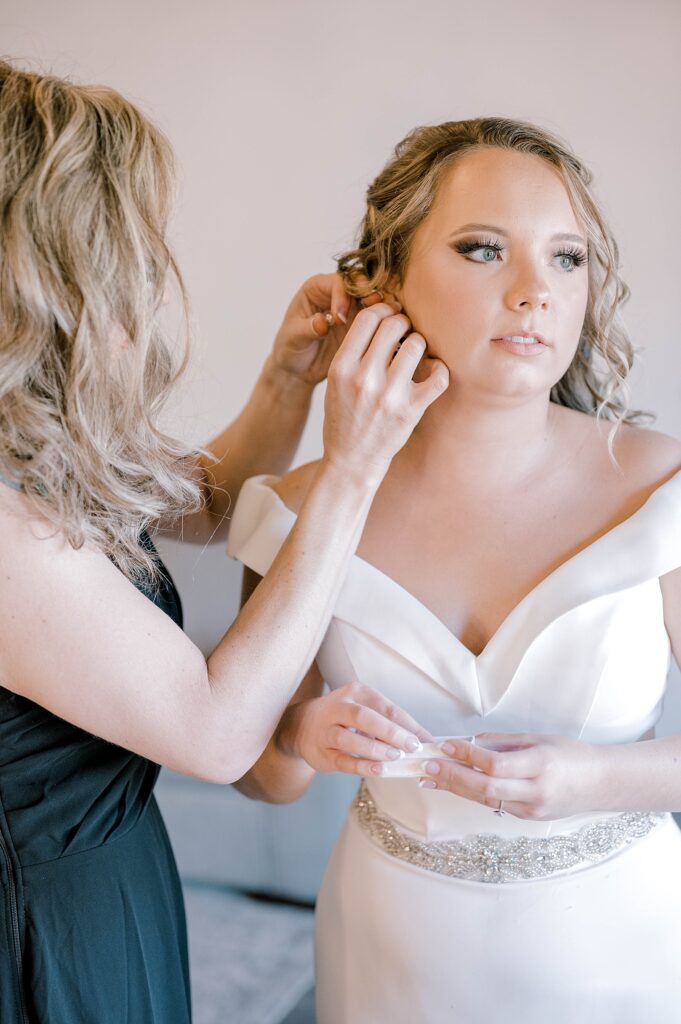 Bride putting on earrings at Stonebrook Meadows